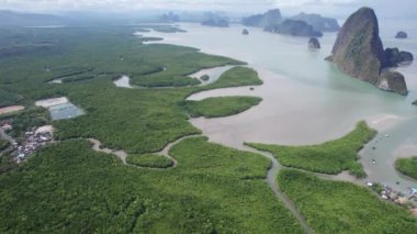 İHA 'dan körfez, nehir ve Phang Nga adaları. Yeşil renkli mangrovların arasından uzun bir nehir akar. Ağaçları ve plajları olan yüksek kireçtaşı kayalıkları. Bulutlu gökyüzü. Avatar Kayası. Phuket, Tayland