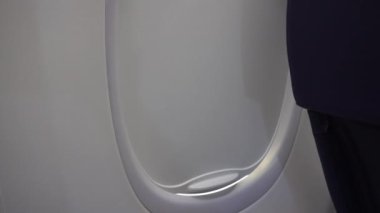 Bulutların üzerindeki uçağın penceresinden bak. Perde açılıyor. Farklı şekillerde beyaz bulutlar. Ada ve deniz gözden kaçmış. Türbin ve uçağın kanadı sallanıyor.