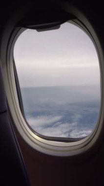 Bulutların üzerindeki uçağın penceresinden bak. Perde açılıyor. Farklı şekillerde beyaz bulutlar. Ada ve deniz gözden kaçmış. Türbin ve uçağın kanadı sallanıyor.