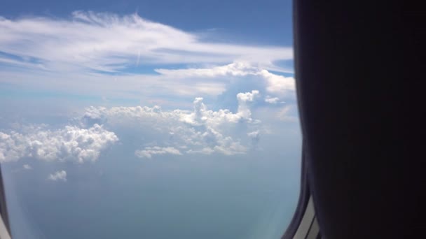 从云层上的飞机窗口观看 帷幕打开了不同形状的白云 小岛和大海被忽视了 涡轮和飞机的机翼在摇晃 — 图库视频影像