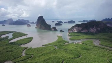 İHA 'dan körfez, nehir ve Phang Nga adaları. Yeşil renkli mangrovların arasından uzun bir nehir akar. Ağaçları ve plajları olan yüksek kireçtaşı kayalıkları. Bulutlu gökyüzü. Avatar Kayası. Phuket, Tayland