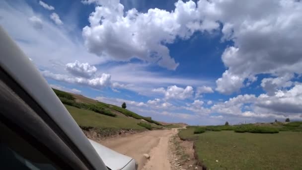 언덕을 Suv를 자동차는 가파른 기울기와 잔디를 드라이브 하늘에는 구름이 있습니다 — 비디오