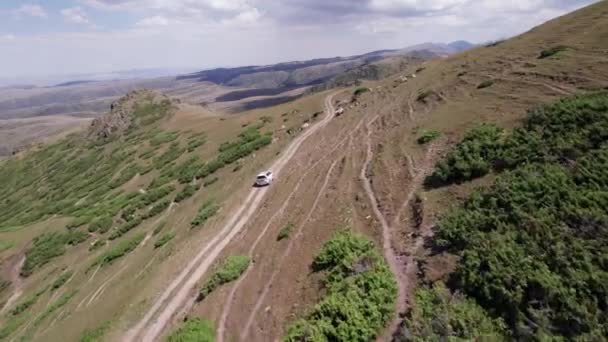 White Suv Overcomes Mountain Route Gorge River Green Fields Cliffs — Stock Video