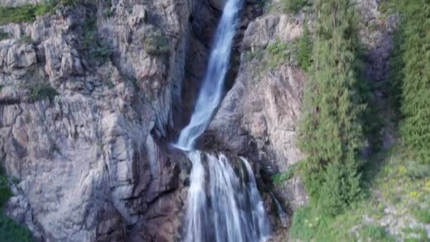 Une cascade haute cascade dans une gorge de montagne. Les conifères, les arbres de Noël et l'herbe poussent. La rivière coule. Sentiers de randonnée. Vue de dessus depuis un drone. Coucher de soleil. Cascade Burkhan Bulak, Kazakhstan