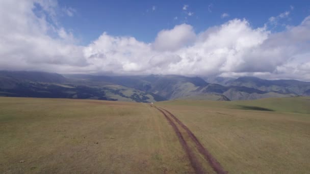 Suv Bianco Sta Guidando Montagna Attraverso Campi Vista Aerea Drone — Video Stock