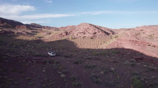 Zwischen Den Roten Bergen Der Steppe Fährt Ein Weißer Geländewagen — Stockvideo
