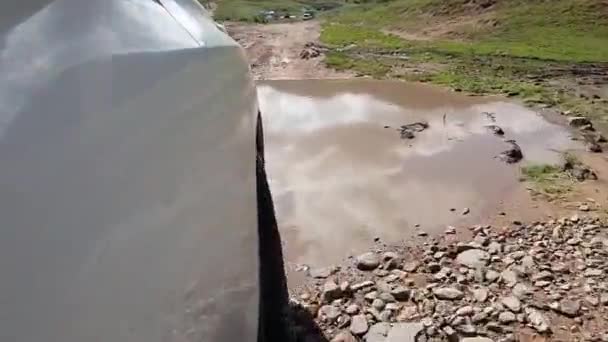 一辆白色越野车驶过河流和泥泞 车轮的视图 白色的油漆反映了周围的世界 — 图库视频影像