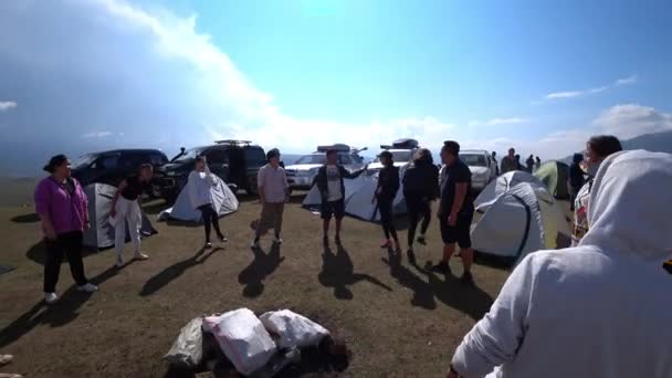 一群人在大自然中玩球 形成一个圆圈 把球扔出去 一个帐篷营地和那里有汽车 2022 Assy Plateau Kazakhstan — 图库视频影像