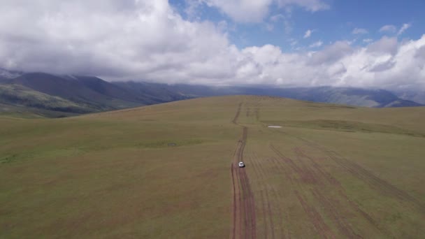 Suv Blanco Está Conduciendo Las Montañas Través Los Campos Vista — Vídeos de Stock