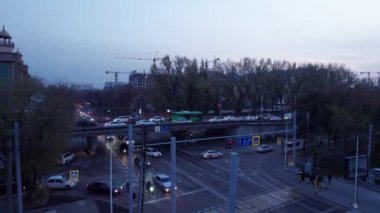 Bir sürü araba, otobüs ve kamyonla dolu yoğun bir kavşak. Gece yolundaki İHA 'nın, şehrin ve yayaların hava görüntüsü. Işıklar ve farlar parlıyor. Trafik sıkışıklığı oluştu. Almaty