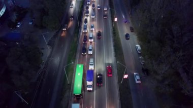 Bir sürü araba, otobüs ve kamyonla dolu yoğun bir kavşak. Gece yolundaki İHA 'nın, şehrin ve yayaların hava görüntüsü. Işıklar ve farlar parlıyor. Trafik sıkışıklığı oluştu. Almaty