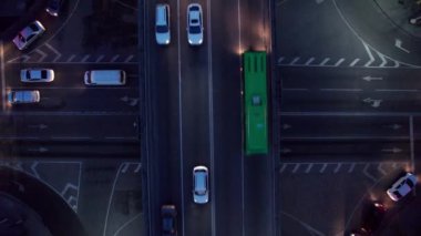 Bir sürü araba, otobüs ve kamyonla dolu yoğun bir kavşak. Gece yolundaki İHA 'nın, şehrin ve yayaların hava görüntüsü. Işıklar ve farlar parlıyor. Trafik sıkışıklığı oluştu. Almaty