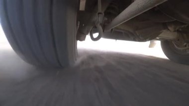 Kamera arabanın altına sabitlenmiş, direksiyon ve süspansiyon manzarası. Off-road, kayalar ve toz. Süspansiyon off-road ve tümsekler iyi çalışıyor. Terk edilmiş bölge. Lastik deformasyonu