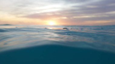 Sakin günbatımı, durgun okyanus suyuna sıcak turuncu ve pembe renkler dökerek güzellik ve barışçıl yansımalarla dolu sakin bir atmosfer yaratır.