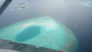 Kristal berrak turkuaz su ve beyaz kumla güzel bir tropikal adanın havadan görünüşü, Hint Okyanusu 'ndaki Maldivler takımadasının bir parçası, bir uçaktan görüldü.