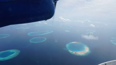 Maldivler adalarının nefes kesici manzarası kristal berrak turkuaz suları ve deniz uçağından görülen beyaz kumlu plajları olan tropikal bir cennet.