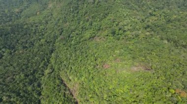 Verdant tropikal ormanlar yemyeşil tepeler, yavaş yavaş sakin okyanus sularına doğru iniyor, küçük şehir Tayland adası cennetinin manzaralı kıyı şeridi boyunca yuva yapıyor.