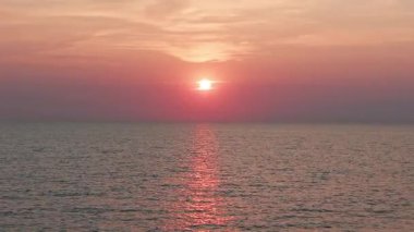 Altın saat gökyüzünü parlak renklerle boyuyor güneş ufka doğru inerken, Koh Chang adası yakınlarındaki Tayland körfezinin sakin sularında ılık bir parıltı saçıyor.