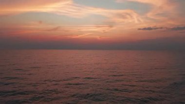 Sıcak turuncu, pembe ve mor tonlarda okyanus yüzeyini canlı günbatımı boyayarak Tayland 'daki sakin koh chang adası kıyı şeridinde büyüleyici yansımalar oluşturuyorlar.