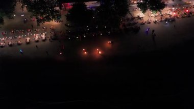 Sıcak ışıklar akşamları sahilde hareketli bir restoranı aydınlatıyor, turistler yemek ve içeceklerin keyfini çıkarırken, hafif dalgalar kıyı şeridine çarpıyor, canlı bir tropikal yemek atmosferi yaratıyor.