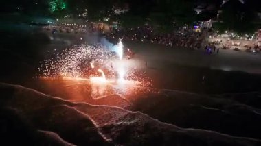 Geceleri kumsalda patlayan renkli havai fişekler kıyı şeridi boyunca toplanan turistler için büyüleyici bir manzara yaratıyor. Karanlık gökyüzünü aydınlatıyor ve okyanus dalgalarını yansıtıyor.