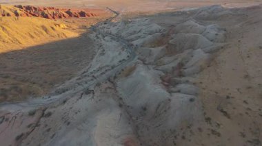 Altın saat aydınlatan, dolambaçlı çöl yolu canlı kanyon manzarasını keserek dramatik jeolojik oluşumları ve dramatik gökyüzünün altındaki geniş vahşi doğayı gözler önüne seriyor.