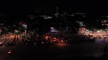 Plaj kenarında turistlerle tropik bir akşam yemeği yerken, ateş dansçısı Endonezya 'daki gili Trawangan Adası' nda büyüleyici bir sahne performansı sergiliyor.