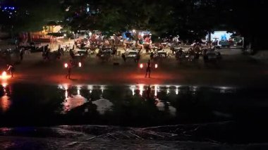 Sahil lokantaları yıldızlı Tayland gecelerinde otantik ateş gösterilerinin tadını çıkarıyorlar, büyüleyici alev dansçılarıyla canlı kültürel eğlenceleri yakalıyorlar.