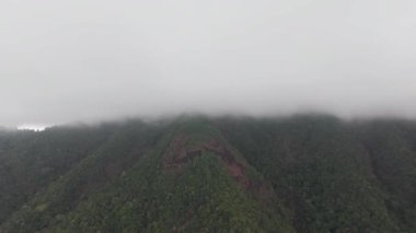 Koh Chang adası büyüleyici doğal güzelliğini sergiliyor yemyeşil dağlarla kısmen beyaz bulutlardan oluşan kalın bir örtüyle örtülü, dingin ve büyüleyici bir manzara yaratıyor.