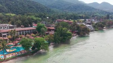 Panoramik hava manzarası lüks koh chang adasını gösteriyor, yeşil ormanla aydınlık turkuaz sular arasında el değmemiş bir tatil beldesi, dingin tropikal cenneti yakalıyor.
