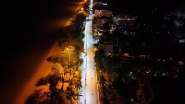 Pattaya sahil yolunu aydınlatan, sokak ışıklarıyla parlayan, canlı şehir manzarası, kıyı manzarası ve karanlık akşam gökyüzü altındaki şehir manzarası.