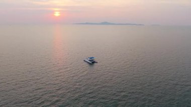 Altın saat güneş ışığı, sakin sularda süzülen tek bir tekneyi aydınlatır. Uzak bir adanın sakin atmosferine eklenerek güzel bir deniz manzarası yaratır.