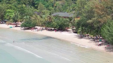 Turkuaz sularla harmanlanmış el değmemiş beyaz kumsal, yemyeşil palmiye ağaçları ve yemyeşil tropikal ormanlar tarafından çerçevelenmiş, tatil kaçamağı için huzurlu bir tropik cennet yaratıyor.