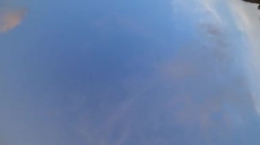 Sakin su yüzeyi, masmavi gökyüzünü ve yumuşak bulutları nazikçe yansıtıyor, berrak, barışçıl atmosferli ve parlak yansımalı sakin bir ortam yaratıyor.