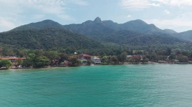 Koh Chang Adası, Trat, Tayland 'ın görkemli dağlık zeminine karşı yeşil tropik orman yamaçlarını kucaklayan çarpıcı turkuaz sularını gözler önüne seriyor.