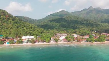 Turkuaz sular, yemyeşil tepelerin arasına kurulmuş tropikal bir sahil beldesinin kumlu sahillerine nazikçe sarılarak muhteşem bir tatil beldesi oluşturur.
