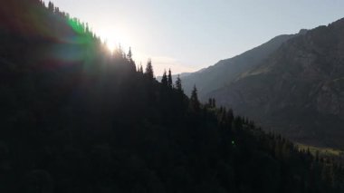 Altın güneş ışığı, sık ve yemyeşil ormanlarla bezenmiş nefes kesici bir dağ vadisini yavaş yavaş gözler önüne seriyor.