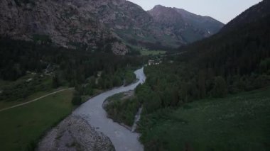Şafak sökerken sakin bir dağ vadisinde bir nehir, bereketli ormanlar ve kayalık arazide kıvranıyor.