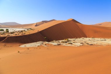 Kum tepesinden Sossusvlei 'nin tuz tepesine inanılmaz bir manzara. Namib Naukluft Ulusal Parkı. Sossusvlei 'deki kum tepeleri. Gün doğumu. Namibya. Afrika.