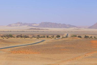 Kum tepesinden Sossusvlei 'nin tuz tepesine inanılmaz bir manzara. Namib Naukluft Ulusal Parkı. Sossusvlei 'deki kum tepeleri. Gün doğumu. Namibya. Afrika.