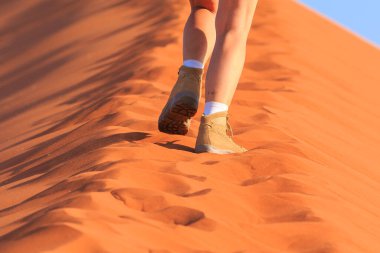 Sesriem, Sossusvlei, Namibya - 30 Eylül 2018: Meşhur Meindl markasının ayakkabılarını giyen bir turist. Dağ, tırmanma ve yürüyüş ayakkabıları. Ünlü kum tepesi 45..