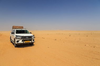 Swakopmund, Namibya - 02 Ekim 2018: Namibya 'da kamp malzemeleri ve bir çatı çadırıyla donatılmış tipik 4x4 kiralık araba. Namibya vahşi doğası.
