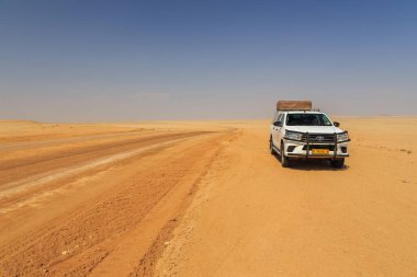 Swakopmund, Namibya - 02 Ekim 2018: Namibya 'da kamp malzemeleri ve bir çatı çadırıyla donatılmış tipik 4x4 kiralık araba. Namibya vahşi doğası.