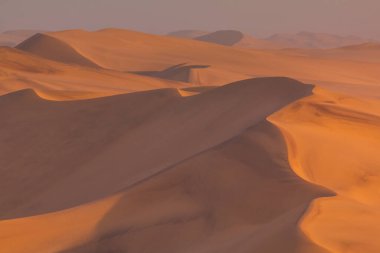 Namib-Naukluft Ulusal Parkı 'ndaki Namib Çölü' nün kuzey tarafında gün batımı. Atlantik Okyanusu açıklarında çöl, Walvis Körfezi. Swakopmund, Namibya.