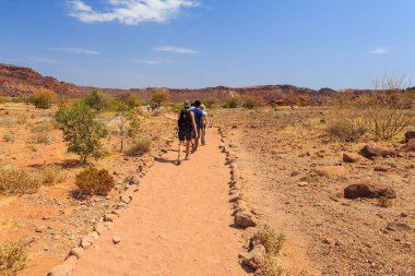 Twyfelfontein, Damaraland, Namibia - 05 October 2018: Tourists in Twyfelfontein, site of ancient rock engravings in the Kunene Region of north-western Namibia. Prehistoric Bushman engravings, rock painting.