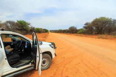 Namibia - 08 October 2018: White car on gravel road to Waterberg Plateau National Park.Beautiful african landscape.