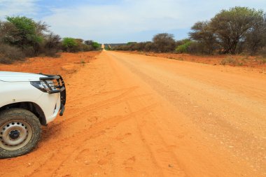 Namibia - 08 October 2018: White car on gravel road to Waterberg Plateau National Park.Beautiful african landscape.