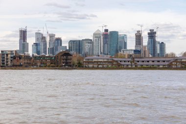 Londra, Greenwich, İngiltere - 05 Nisan 2019: Bulutlu gökyüzünde Londra şehrinin ufuk çizgisinin görüntüsü. Thames nehrinin dibinde..