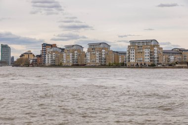 Londra, Greenwich, İngiltere - 05 Nisan 2019: Bulutlu gökyüzünde Londra şehrinin ufuk çizgisinin görüntüsü. Thames nehrinin dibinde..