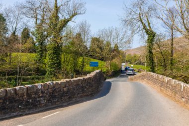 Sedbergh, Yorkshire, İngiltere - 20 Nisan 2019: Sedbergh 'deki Rawthey Nehri üzerindeki taş köprüde bir yol. Bahar mevsimi.